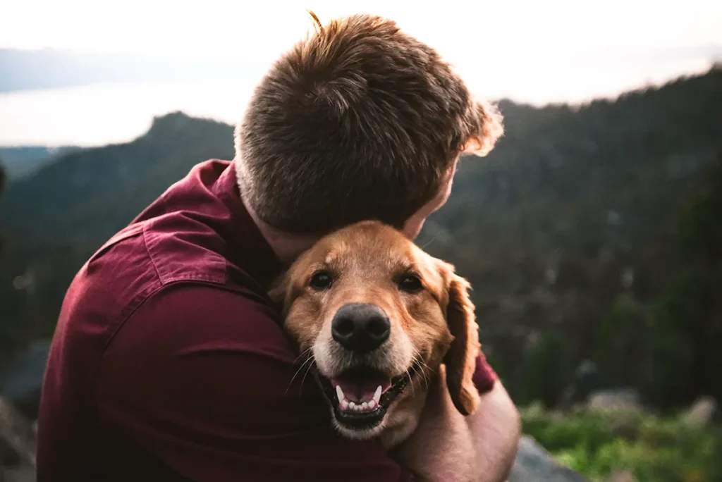 Man enbracing his pet dog